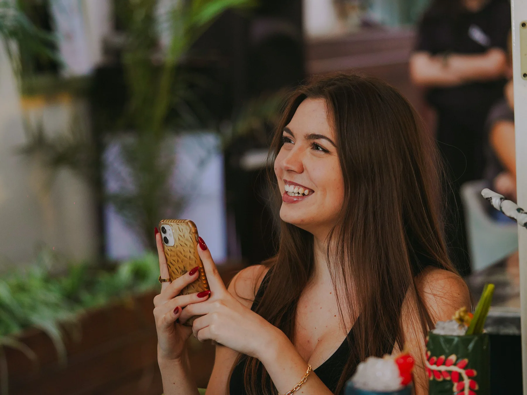 Una clienta consulta el seu telèfon en un restaurant lluminós