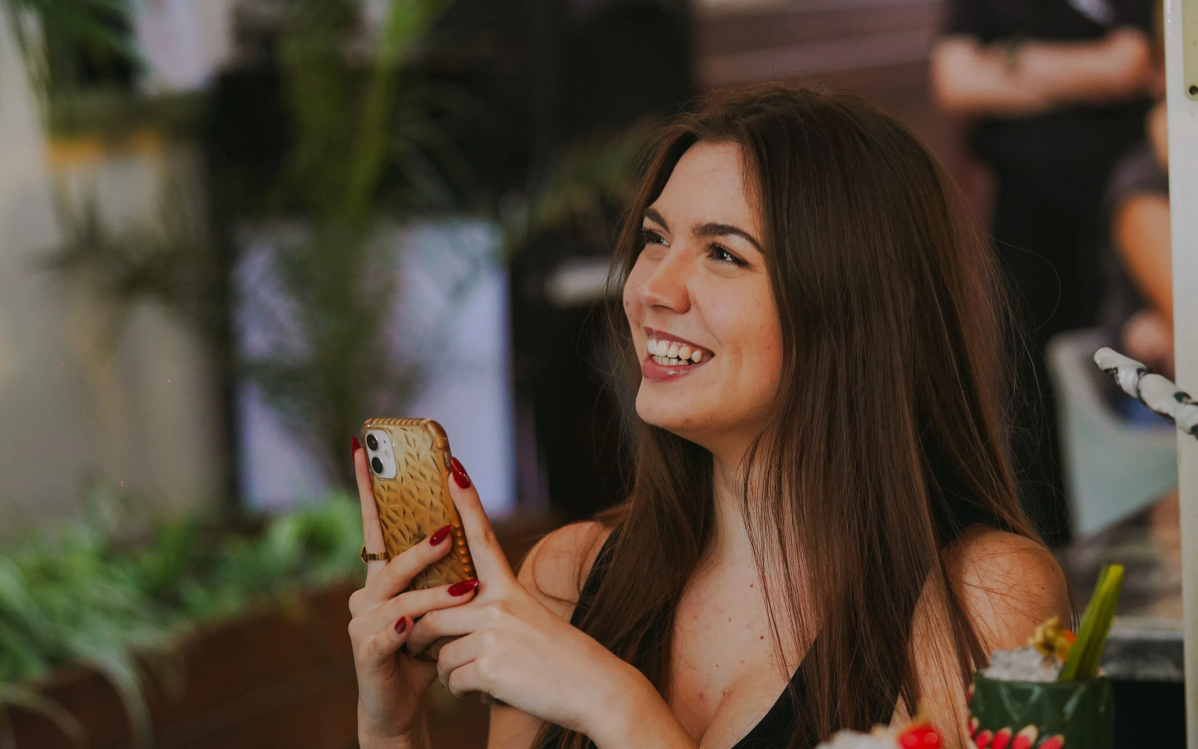 Una clienta consulta el seu telèfon en un restaurant lluminós