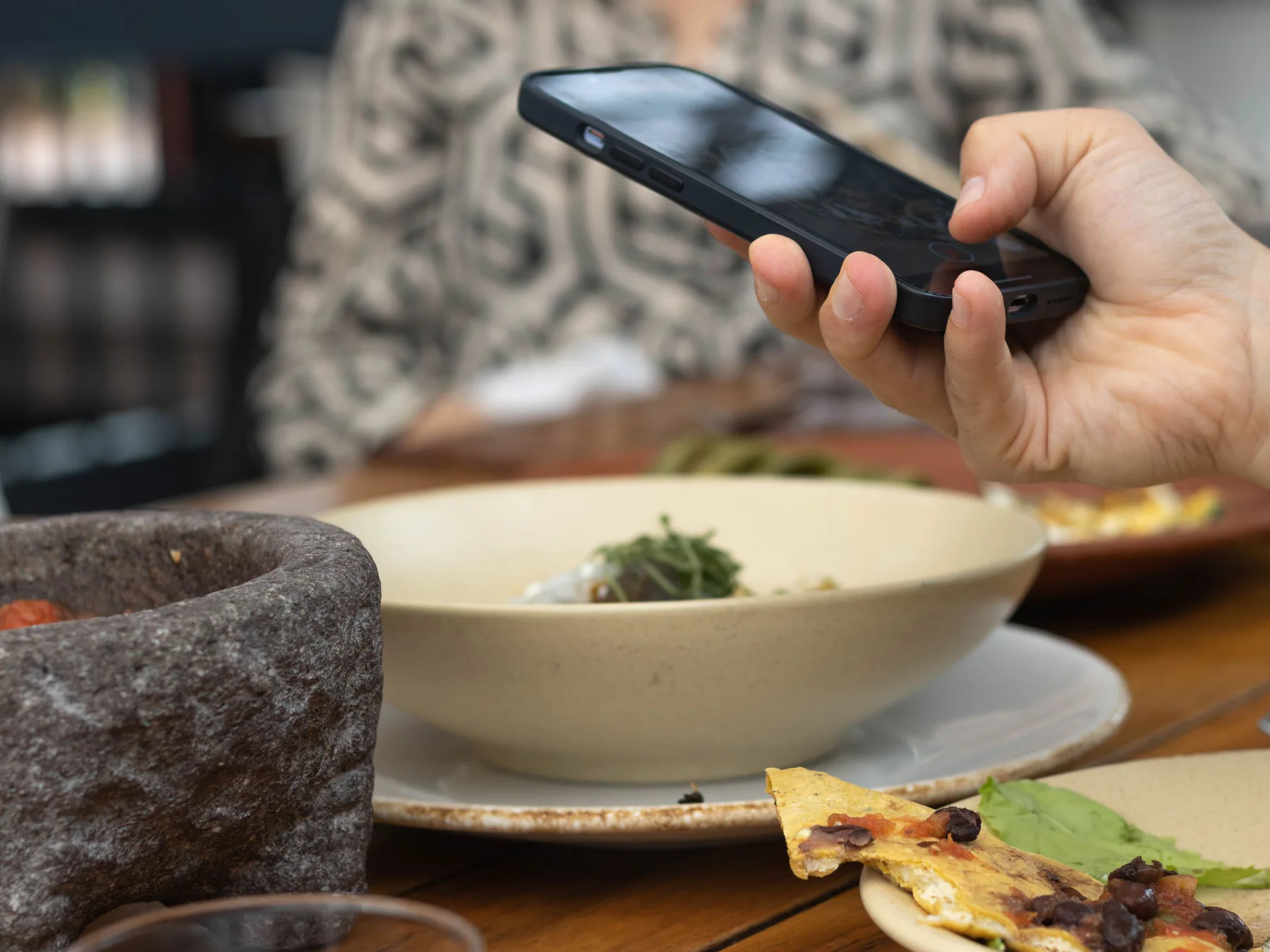 Una persona fotografia un plat servit en un restaurant